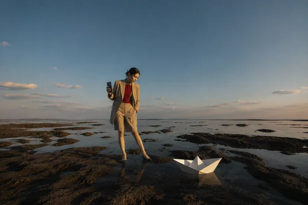 Paper Boat storyboard frame 3: a man at a tidal shore at sunset with a paper boat and a Fold8