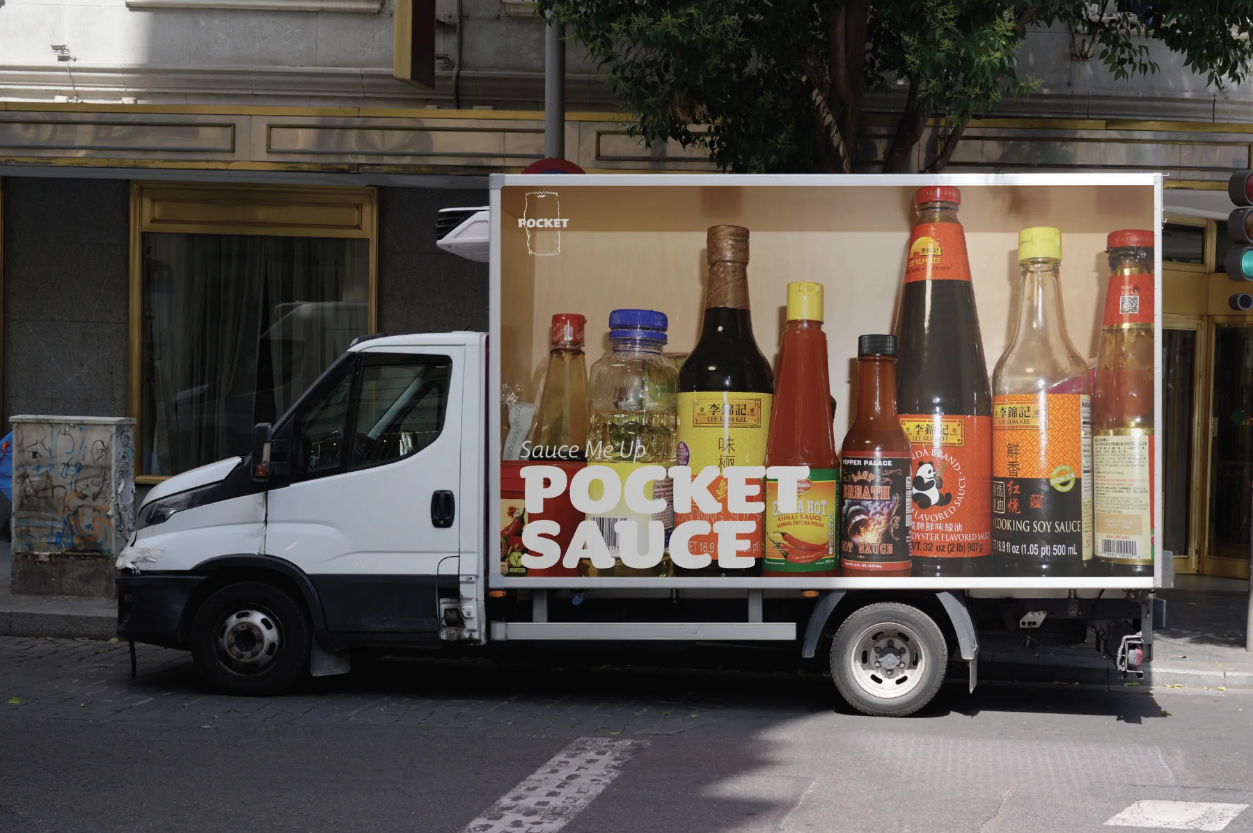 A box truck whose side panel shows a shelf of sauce bottles under the Pocket Sauce logo, parked on a city street